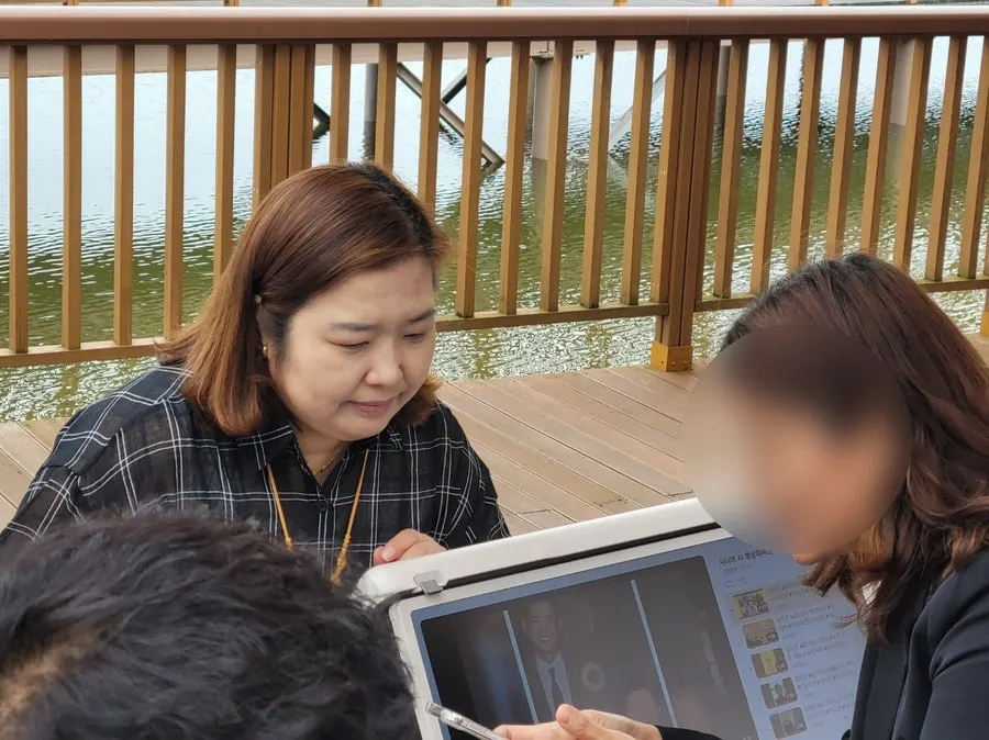 부스에서 노트북 화면을 함께 보는 강사와 시민