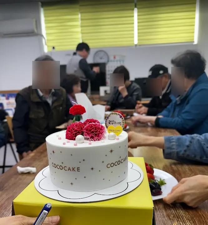 케이크를 가운데 두고 둘러앉은 수강생들